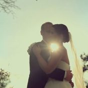 Hochzeitswahn - Eine Braut und ein Bräutigam umarmen sich vor der Sonne.
