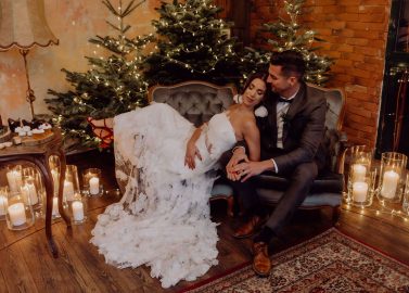Hochzeitswahn - Ein Mann und eine Frau sitzen auf einer Couch vor einem Weihnachtsbaum.