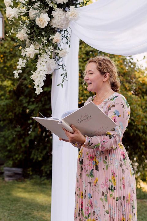 Hochzeitswahn - Eine Frau in einem Blumenkleid liest ein Buch.