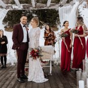 Hochzeitswahn - Eine Gruppe von Menschen steht auf einer Terrasse im Schnee.