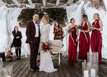 Hochzeitswahn - Eine Gruppe von Menschen steht auf einer Terrasse im Schnee.